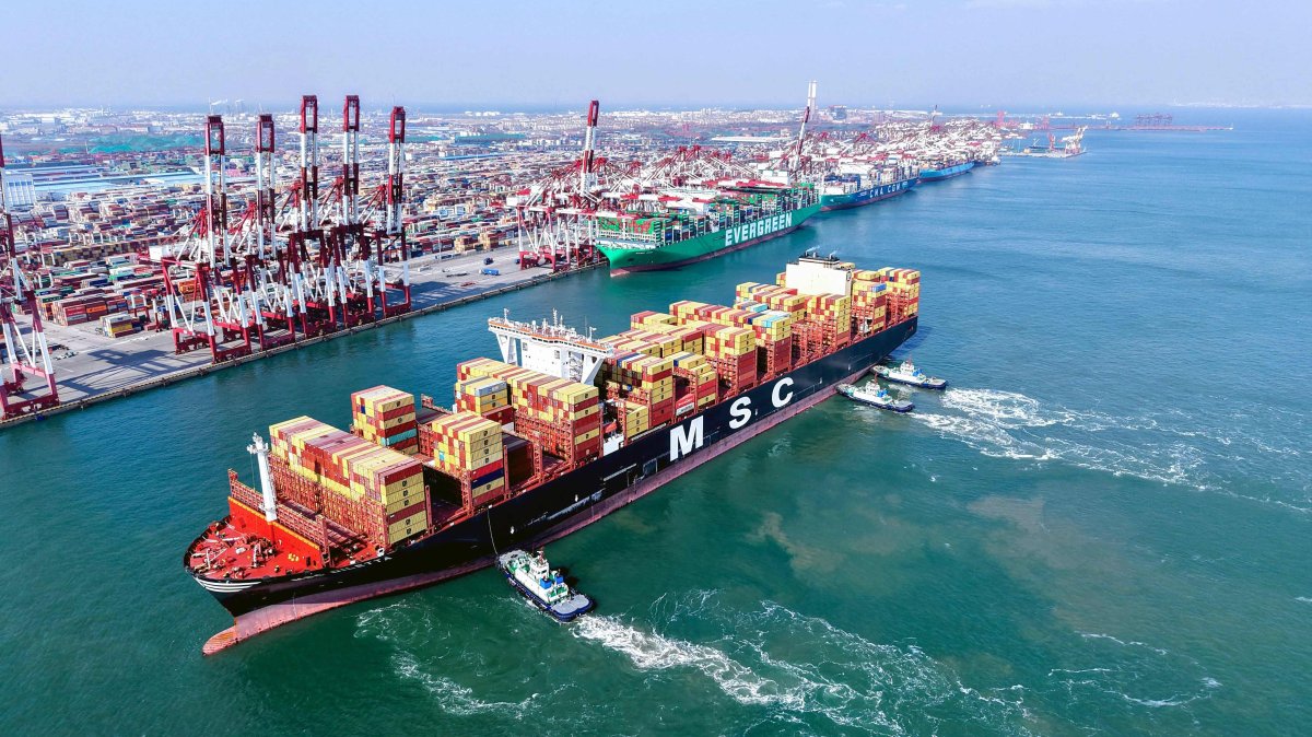 An aerial view shows a container ship being guided to its berth by tugboats at Qingdao port in China’s eastern Shandong province, Feb. 23, 2025. (AFP Photo)