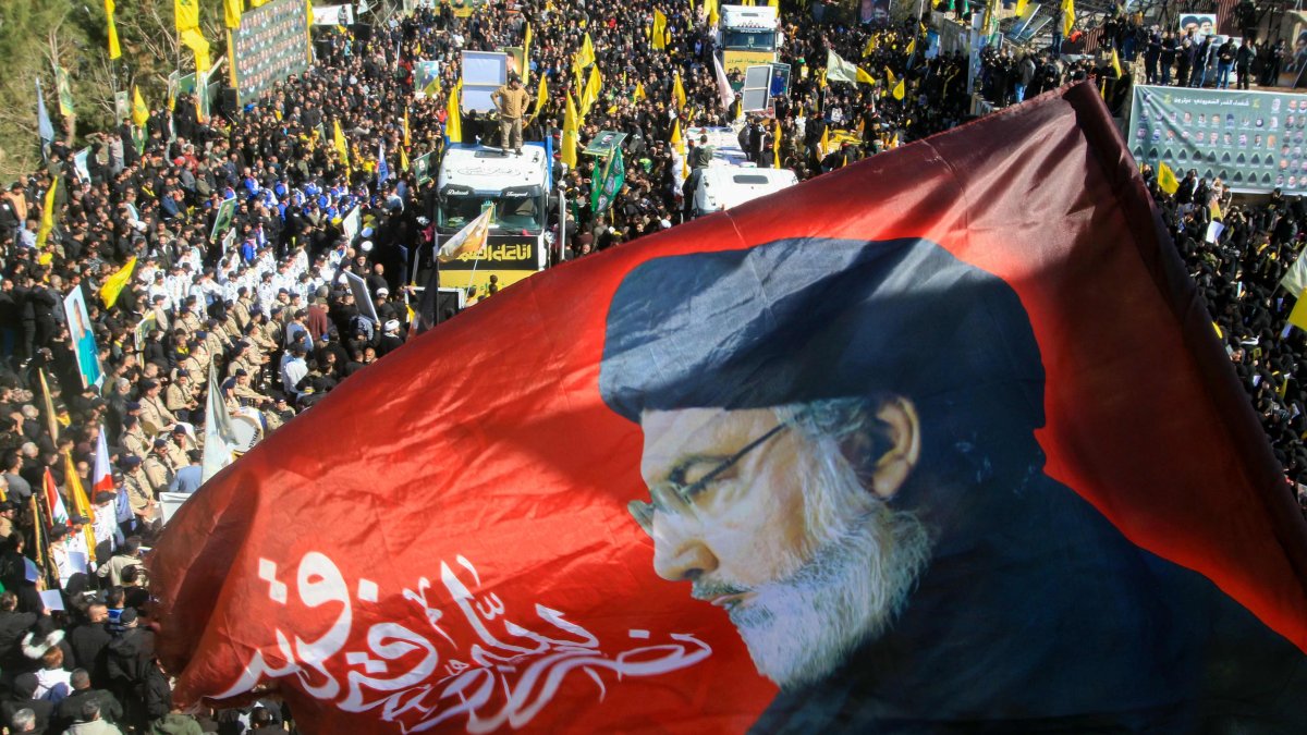 A flag bearing a portrait of slain Hezbollah leader Hassan Nasrallah waves during the funeral of 95 Hezbollah fighters and civilians killed in Israeli airstrikes during hostilities that lasted more than a year between Israel and Hezbollah, in the southern border town of Aitaroun, Lebanon, Feb. 28, 2025. (AFP Photo)