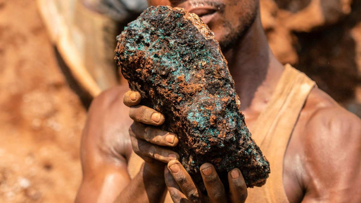 Dela wa Monga, an artisanal miner, holds a cobalt stone at the Shabara artisanal mine near Kolwezi, DRC, Oct. 12, 2022. (AFP Photo)