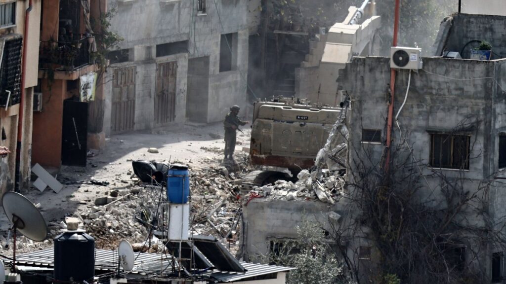An Israeli soldier looks on as a military excavator demolishes a building in the Nur Shams camp for Palestinian refugees east of Tulkarem, amid an ongoing offensive in the occupied-West Bank, March 6, 2025. (AFP Photo)