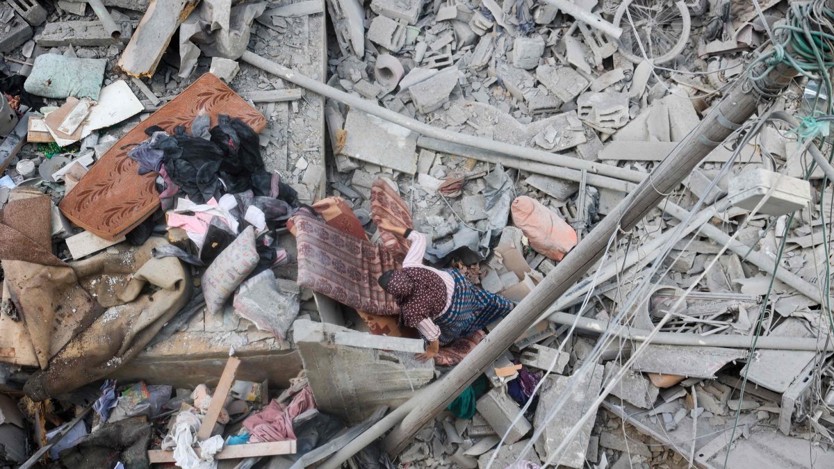 A woman searches through the rubble of her home, destroyed in an Israeli strike, for salvageable items at the Nuseirat refugee camp, Gaza Strip, Palestine, March 18, 2025. (AFP Photo)