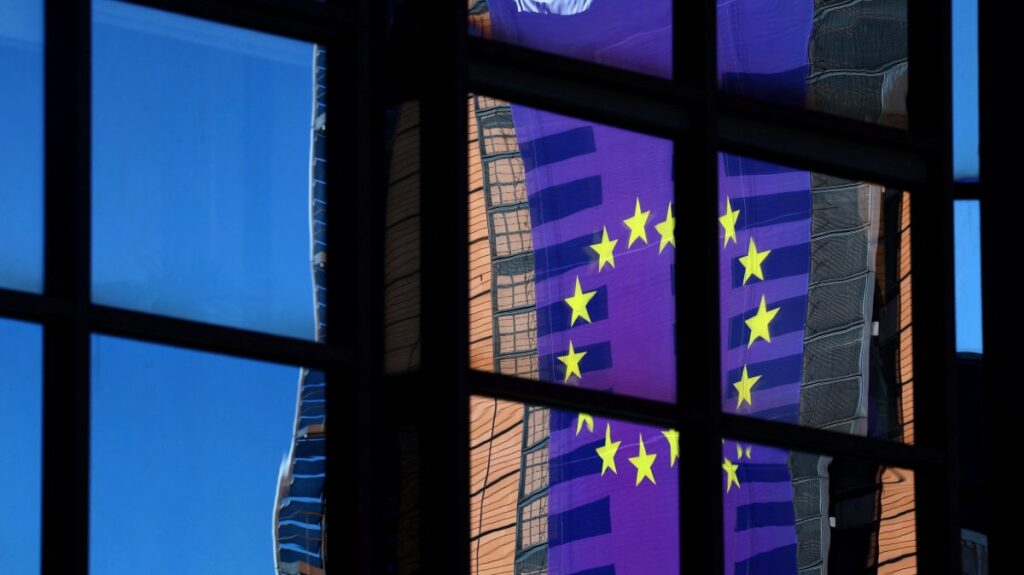 A banner depicting an European Union flag is reflected in a window outside the EU Council headquarters in Brussels, Belgium March 18, 2025. REUTERS/Yves Herman