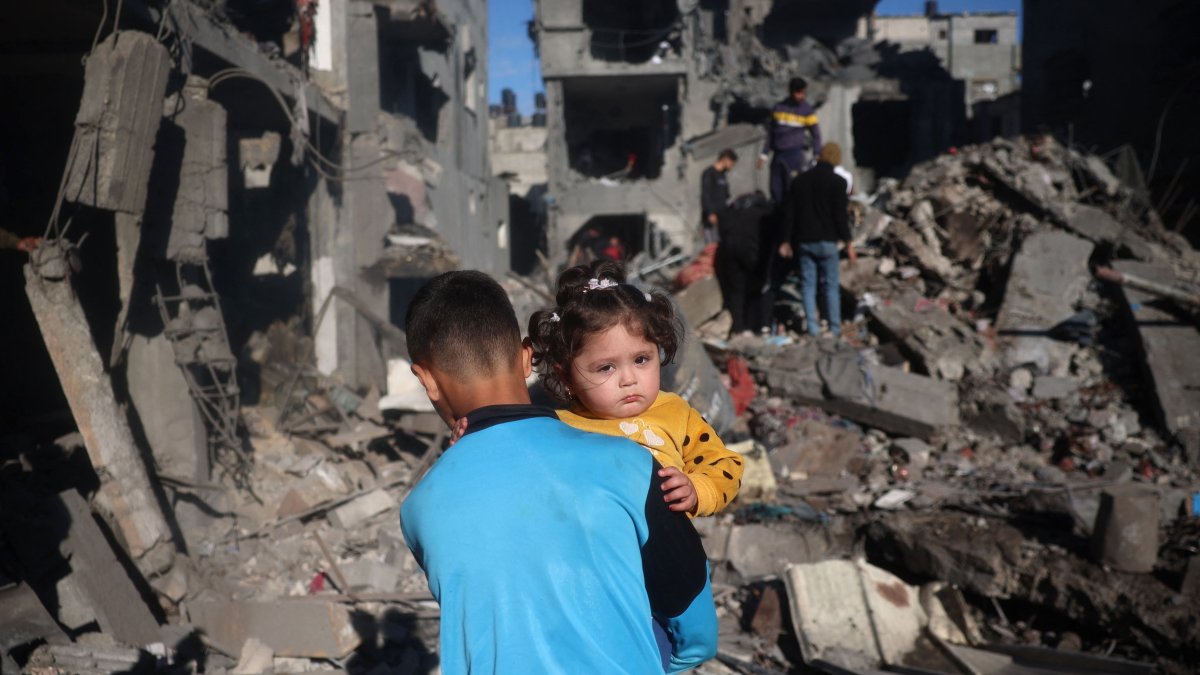 Palestinian children react as they inspect the rubble and debris at the site of Israeli strikes at the Nuseirat refugee camp, central Gaza Strip, March 23, 2025. (AFP Photo)