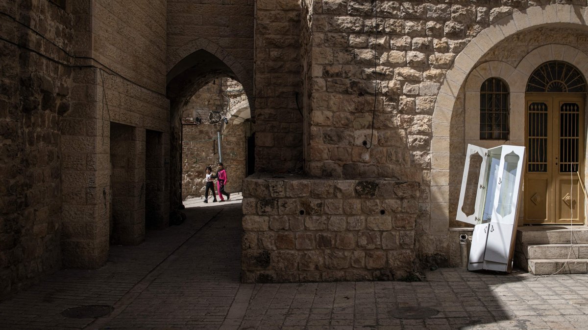 Palestinian girls walk near uninhabited houses in old Hebron in the occupied West Bank, Palestine, April 3, 2025. (AFP Photo)