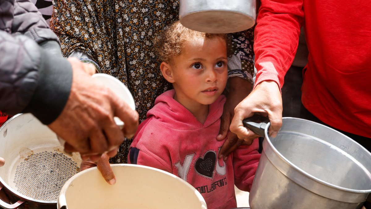 A child looks on as Palestinians wait to receive food cooked by a charity kitchen, in Khan Younis, southern Gaza Strip, Palestine, April 6, 2025. (Reuters Photo)