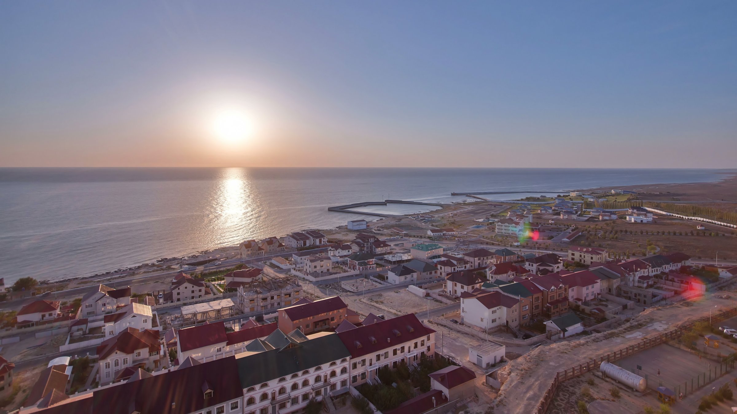 A sunset view over the Caspian Sea with Aktau's cityscape stretching along the shoreline, Kazakhstan. (Shutterstock Photo)