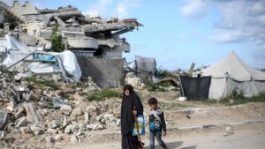 A displaced Palestinian woman and child walk past the rubble of a destroyed building in the Gaza Strip, Palestine, April 10, 2025. (AFP Photo)