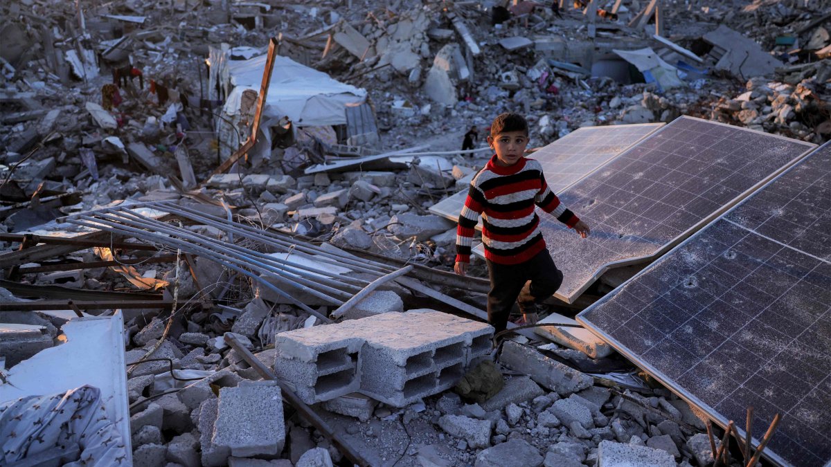 A boy walks past broken solar panels amidst rubble in Jabalia in the northern Gaza Strip, Palestine, April 14, 2025. (AFP Photo)