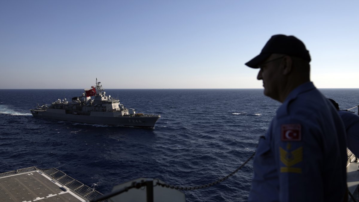 A Turkish officer looks at a naval ship during an annual NATO naval exercise on Türkiye's western coast on the Mediterranean, Sept. 15, 2022. (AP Photo)