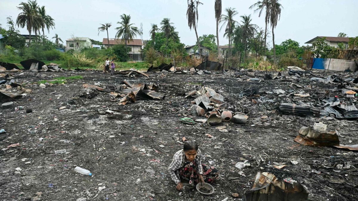 A woman searches for items among the debris of houses destroyed in an earthquake-sparked fire in Mandalay, April 11, 2025. (AFP Photo)