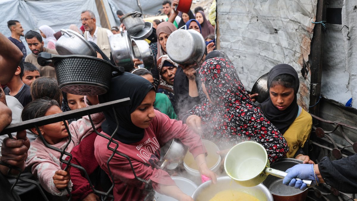 Palestinians wait to receive food cooked by a charity kitchen, in Beit Lahia, northern Gaza Strip, April 24, 2025. (Reuters Photo)