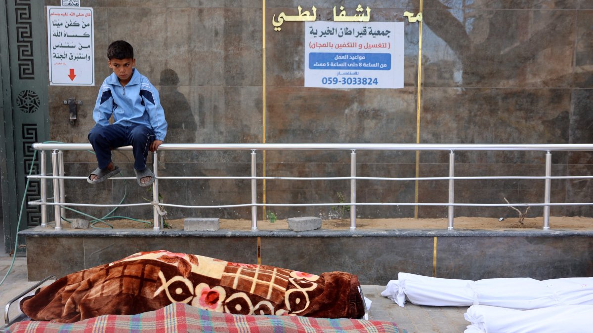 A Palestinian boy sits beside the bodies of the Al-Khour family in the yard of the yard of the Al-Shifa hospital after their house was hit by an Israeli strike in Sabra neighbourhood, Gaza City, the Gaza Strip, April 26, 2025. (AFP Photo)