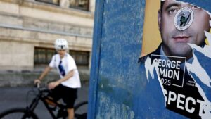 A cyclists rides past an electoral poster depicting suveranist party AUR leader George Simion, leading candidate for 2025 presidential elections, in Bucharest, Romania, May 2, 2025. (EPA Photo)