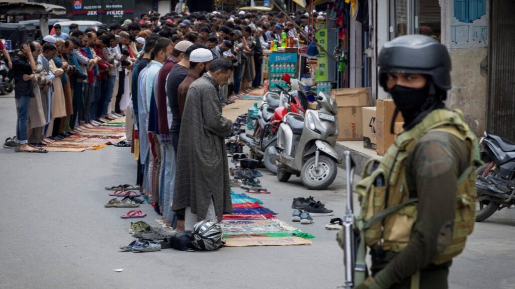 Kashmiri muslims perform Friday prayers on a road as a security personnel stands guard, in Srinagar, May 2, 2025. (Reuters Photo)