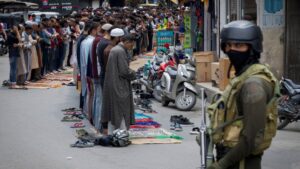 Kashmiri muslims perform Friday prayers on a road as a security personnel stands guard, in Srinagar, May 2, 2025. (Reuters Photo)