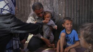 Wedad Abdelaal and her husband Ammar, feed their 9-month-old son, Khaled, in their tent at a camp for displaced Palestinians in Mawasi Khan Younis, Gaza Strip, May 2, 2025. (AP Photo)