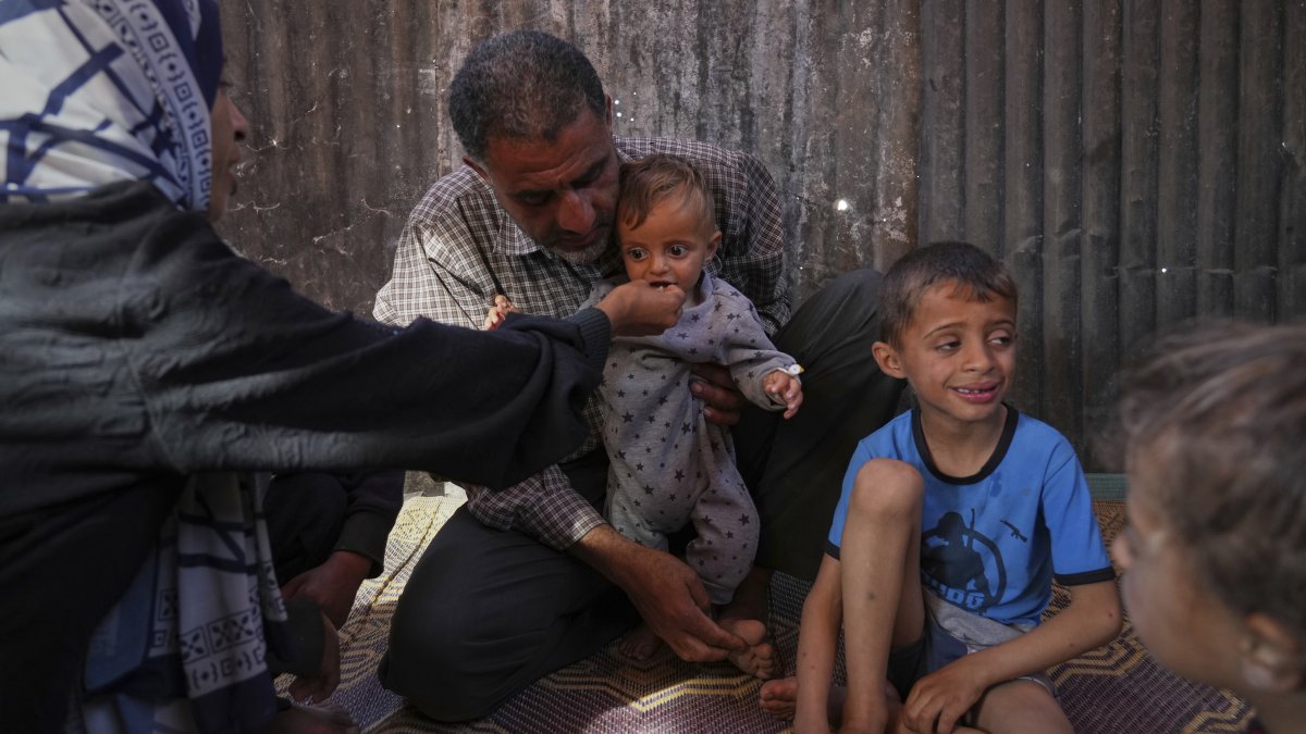 Wedad Abdelaal and her husband Ammar, feed their 9-month-old son, Khaled, in their tent at a camp for displaced Palestinians in Mawasi Khan Younis, Gaza Strip, May 2, 2025. (AP Photo)
