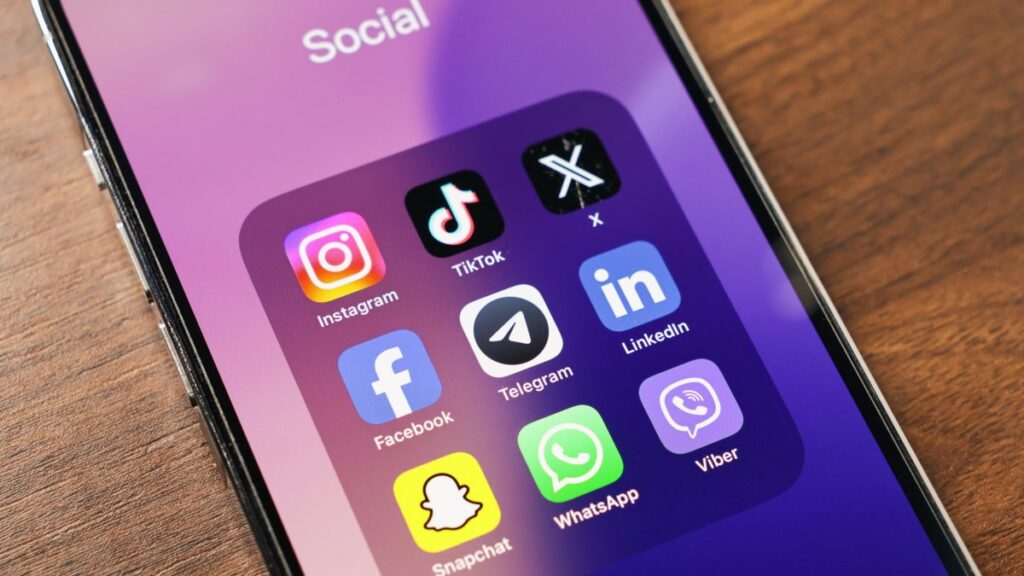 A phone screen displays popular social media apps, including Instagram, TikTok, X, Facebook, Telegram, LinkedIn, Snapchat and WhatsApp. (Shutterstock Photo)