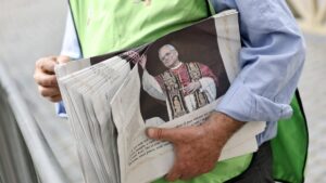 A volunteer distributes copies of the Vatican City daily newspaper "L'Osservatore Romano" the day after Cardinal Robert Prevost is elected Pope Leo XIV, St. Peter's Square, Vatican, May 9, 2025. (EPA Photo)