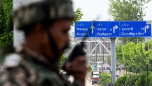 An Indian paramilitary personnel uses a handheld transceiver as he stands guard along a street leading to the international airport in Srinagar, India, May 10, 2025. (AFP Photo)
