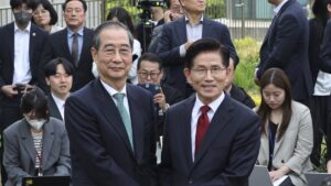 South Korea's People Power Party's presidential election candidate Kim Moon Soo (R) and independent preliminary presidential election candidate Han Duck-soo pose for a photo during a meeting, Seoul, South Korea, May 8, 2025. (AP Photo)