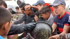 Palestinian youths shove to get a ration of hot food from a charity kitchen set up in Gaza City, central Gaza Strip, Palestine, May 12, 2025. (AFP Photo)