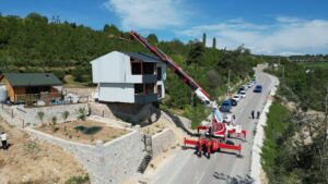A crane moves a three-story steel structure during the demolition of an illegal villa in Inegöl, Bursa, Türkiye, May 13, 2025. (IHA Photo)