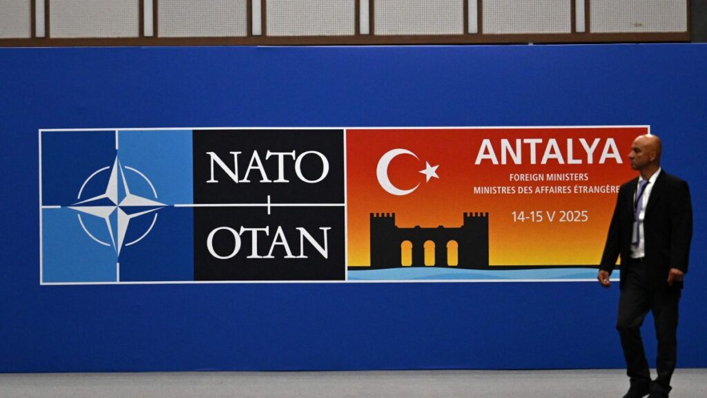 A visitor walks past a board announcing the informal meeting of NATO Ministers of Foreign Affairs, Antalya, Türkiye, May 14, 2025. (AFP Photo)