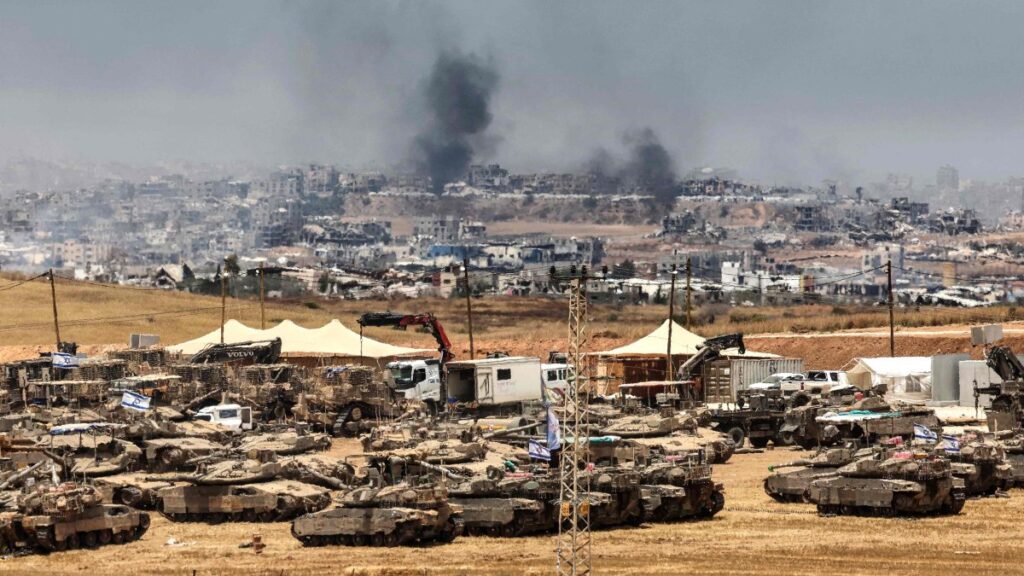This picture taken from a position in southern Israel on the border with the Gaza Strip shows Israeli tanks and bulldozers deployed as smoke billows over destroyed buildings in Gaza during Israeli bombardment, May 17, 2025. (AFP Photo)