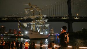 People watch as a Mexican Navy training ship is pulled away after it slammed into the nearby Brooklyn Bridge in New York, U.S., May 17, 2025. (AFP Photo)