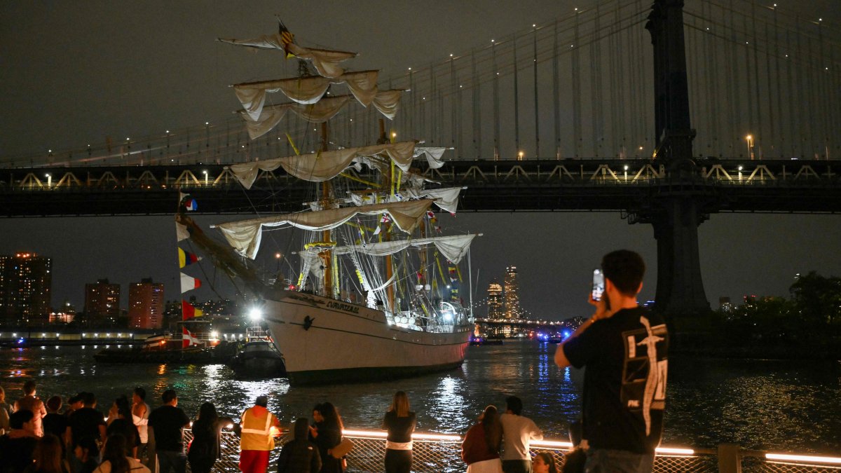 People watch as a Mexican Navy training ship is pulled away after it slammed into the nearby Brooklyn Bridge in New York, U.S., May 17, 2025. (AFP Photo)