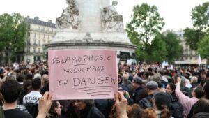 A protestor holds a sign reading "Islamophobia, Muslims in danger" during a gathering in tribute to Aboubakar, the worshipper killed in a mosque at La Grand-Combe, and against Islamophobia, at the Place de la Republique in Paris on April 27, 2025. (AFP Photo)
