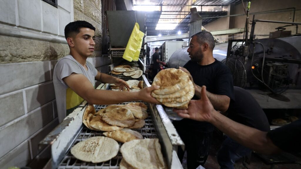 Employees of a bakery in Deir al-Balah stack freshly-baked bread after Israel allowed limited humanitarian aid to enter Gaza, Palestine, May 22, 2025. (AFP Photo)