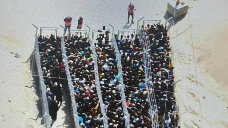 384550 Palestinians are seen in lineups waiting to receive aid in this image obtained from the distribution center set up by the U.S.- and Israeli-supported