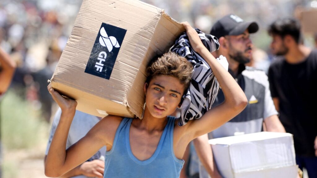 A boy carries a box of relief supplies from the Gaza Humanitarian Foundation (GHF), a private U.S.-backed aid group that has bypassed the longstanding U.N.-led system in the territory, as displaced Palestinians return from an aid distribution center, Gaza Strip, Palestine, May 29, 2025. (AFP Photo)