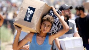 A boy carries a box of relief supplies from the Gaza Humanitarian Foundation (GHF), a private U.S.-backed aid group that has bypassed the longstanding U.N.-led system in the territory, as displaced Palestinians return from an aid distribution center, Gaza Strip, Palestine, May 29, 2025. (AFP Photo)