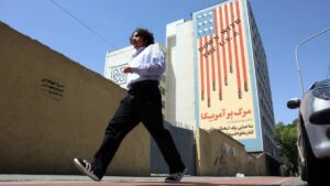 An Iranian man walks past an anti-U.S. mural in Tehran, Iran, May 21, 2025. (EPA Photo)