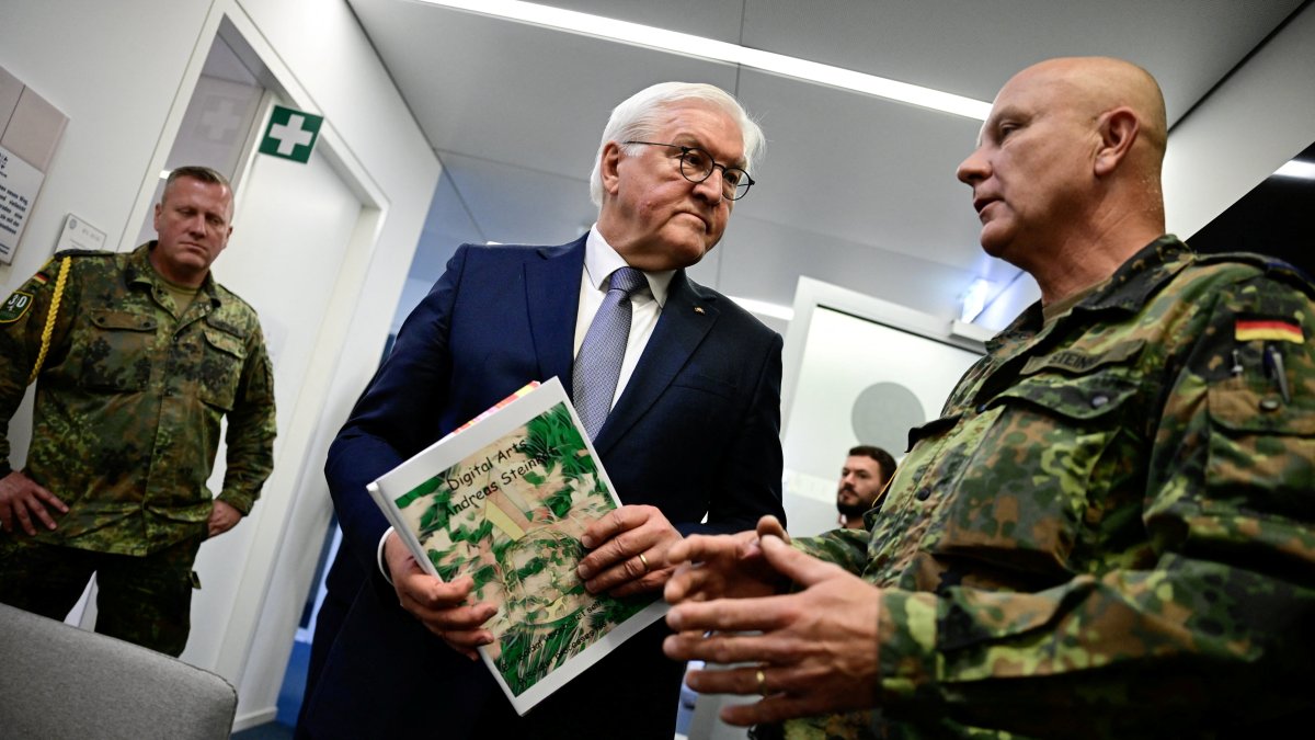 German President Frank-Walter Steinmeier listens to Sergeant Major, medical officer and artist Andreas Steinkat who explains his art pieces hanging in the Veterans Office, in Berlin, Germany, June 3, 2025. (Reuters Photo)