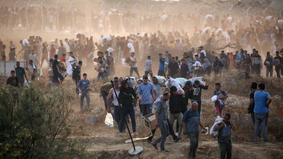 People carry relief supplies from the Gaza Humanitarian Foundation (GHF), a private U.S.-backed aid group that has bypassed the longstanding U.N.-led system in the territory, central Gaza Strip, Palestine, June 8, 2025. (AFP Photo)