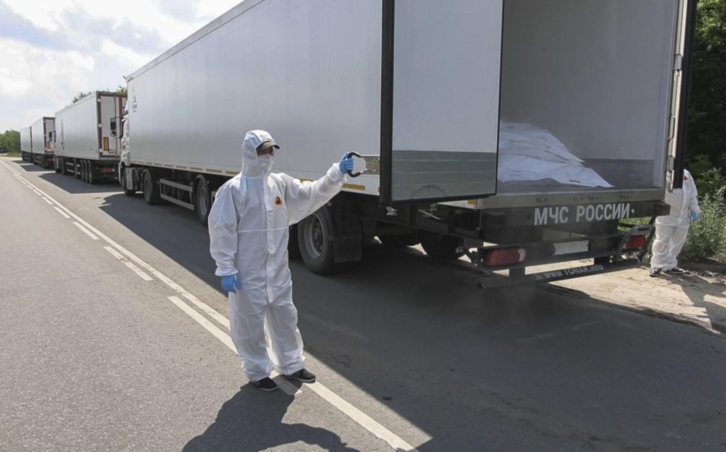 385958 A Russian Defense Ministry personnel wearing a hazmat suit opens a truck, part of a convoy of 1,212 bodies of killed Ukrainian servicemen to be repatriated, as it arrived in the exchange area on the border with Ukraine in Nova Huta, Belarus, June 8, 2025. (EPA Photo)