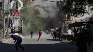 Palestinians rush for cover as debris flies around them after an Israeli strike on the Bureij camp for Palestinian refugees, central Gaza Strip, Palestine, June 15, 2025. (AFP Photo)