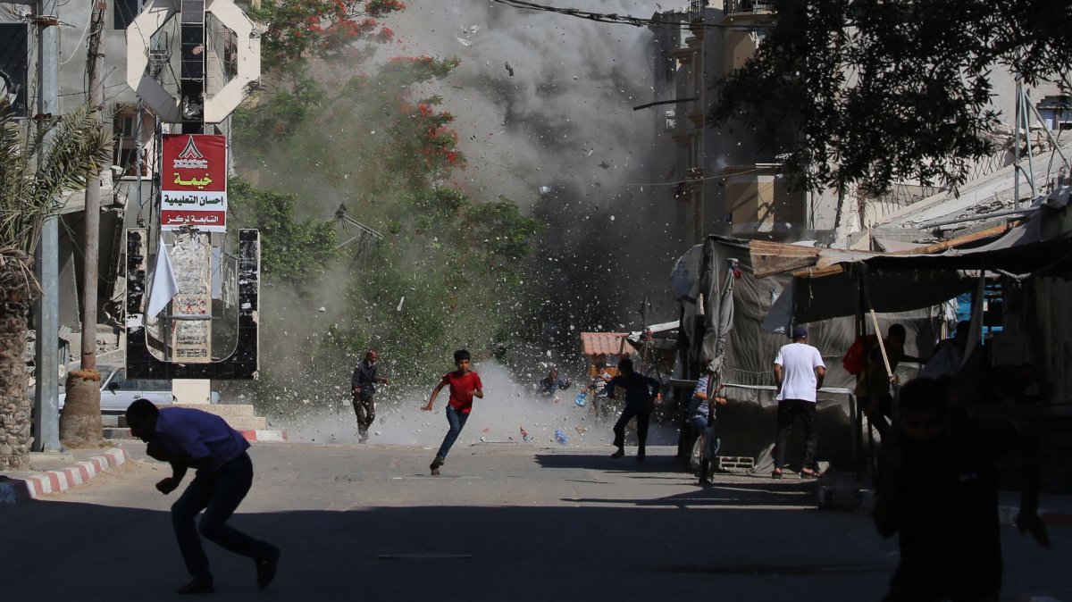 Palestinians rush for cover as debris flies around them after an Israeli strike on the Bureij camp for Palestinian refugees, central Gaza Strip, Palestine, June 15, 2025. (AFP Photo)