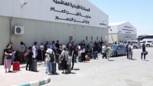 Expats, including diplomats from different nationalities, who were stranded in the occupied West Bank and Israel, wait as they hold belongings while being evacuated through the King Hussein Bridge crossing, South Shuna, Jordan, June 19, 2025. (Reuters Photo)