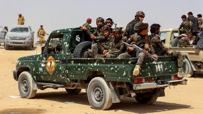 Soldiers ride on the back of a patrol truck during the burial of Brigadier General Abdul-Ghani Shaalan, Commander of the Special Security Forces in Marib, Yemen, February 28, 2021.