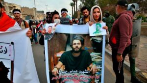 Protesters hold pictures of people who have been killed in anti-government protests during a demonstration calling for the government to resign, in Baghdad, Iraq, on November 29, 2020.
